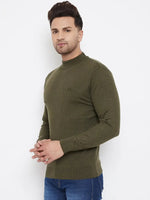 A man in a 98degreenorth Men Merino Wool Olive Turtleneck Pullover and blue jeans stands against a white background, facing the camera with his hands clasped in front.