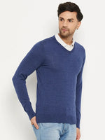 Man in 98degreenorth Men Merino Wool V-Neck Pullover in Light Denim over a white shirt and light blue jeans, on white.