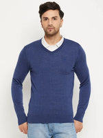 Man wears 98degreenorth Men Merino Wool V-Neck Pullover - Light Denim over a white shirt with light blue jeans.