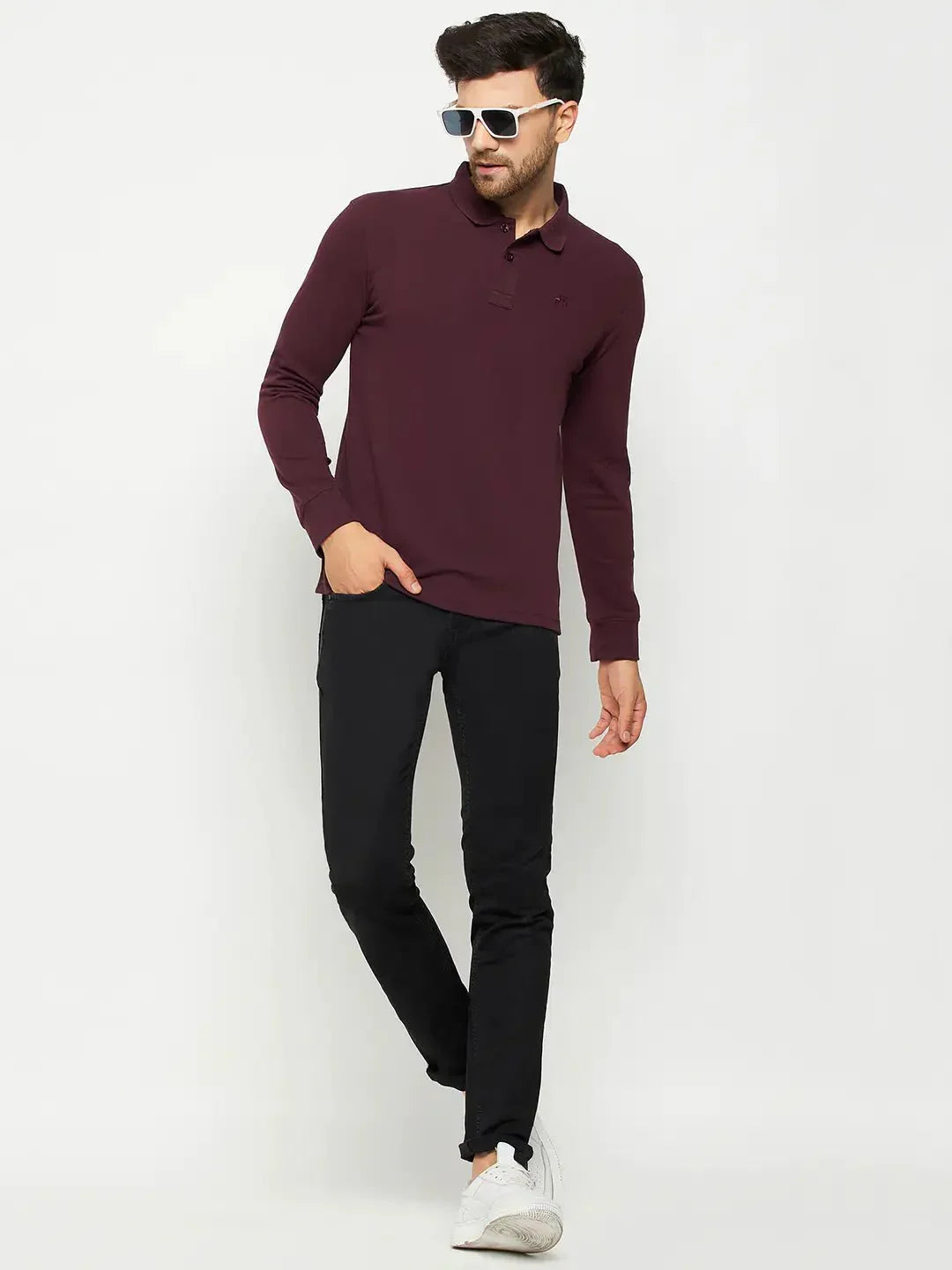Man in 98degreenorth Men Polo Collar Full Sleeves Dark Wine T-shirt, black pants, white sneakers, sunglasses, white background.