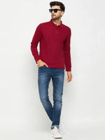 Man wearing a 98degreenorth Men Polo Collar Full Sleeves Maroon T-shirt, blue jeans, and white sneakers.