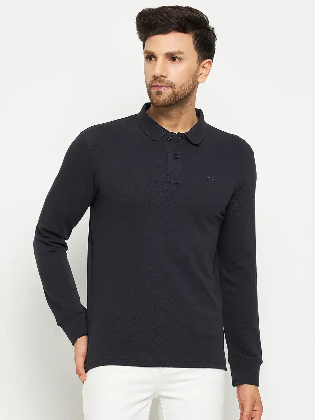 Man in a 98degreenorth Men Polo Collar Full Sleeves Navy T-shirt and white pants, ideal for stylish travel.