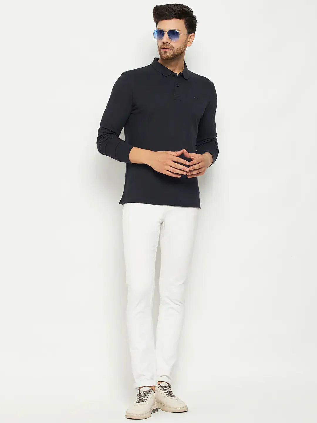 Man wears 98degreenorth Men Polo Collar Full Sleeves Navy T-shirt, white pants, beige shoes, blue sunglasses, on white background.