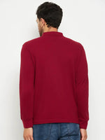 Man models 98degreenorth Men Polo Collar Full Sleeves With Pocket Maroon T-shirt and blue jeans on a white background.