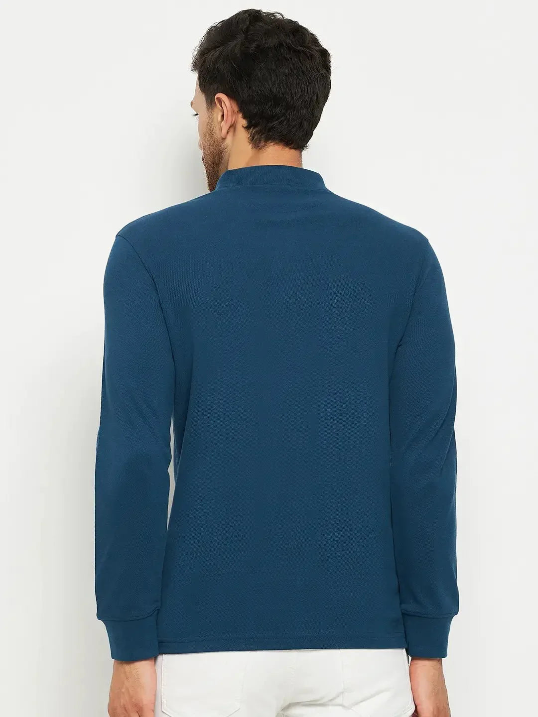 Man wearing 98degreenorth Men Polo Collar Full Sleeves With Pocket Teal T-shirt, paired with white pants, facing away.