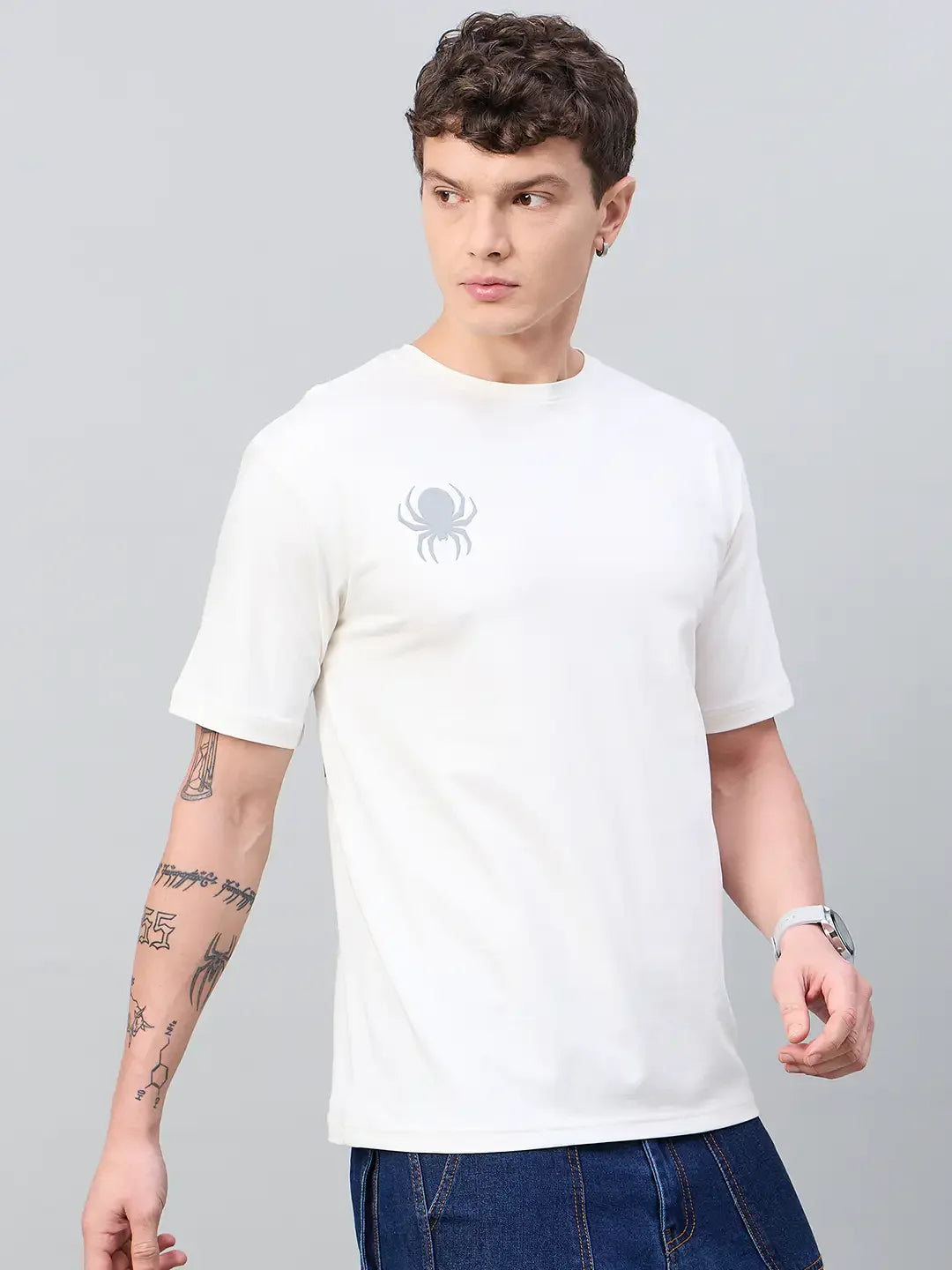 Man in 98degreenorth Men Typography Offwhite Printed Round Neck T-shirt, blue jeans, and visible arm tattoos.