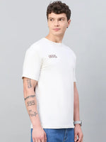 Young man with short curly hair wears a 98degreenorth Men Typography Oversized Offwhite Printed T-shirt and blue jeans.