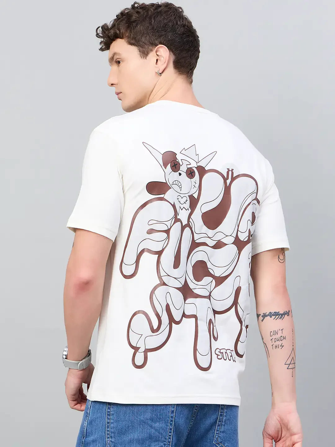 Man in 98degreenorth Men Typography Oversized Offwhite Printed Round Neck T-shirt and blue jeans, facing away.