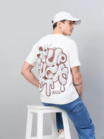 Model wears 98degreenorth Men Typography Oversized Offwhite Printed Round Neck T-shirt, seated against a gray background.