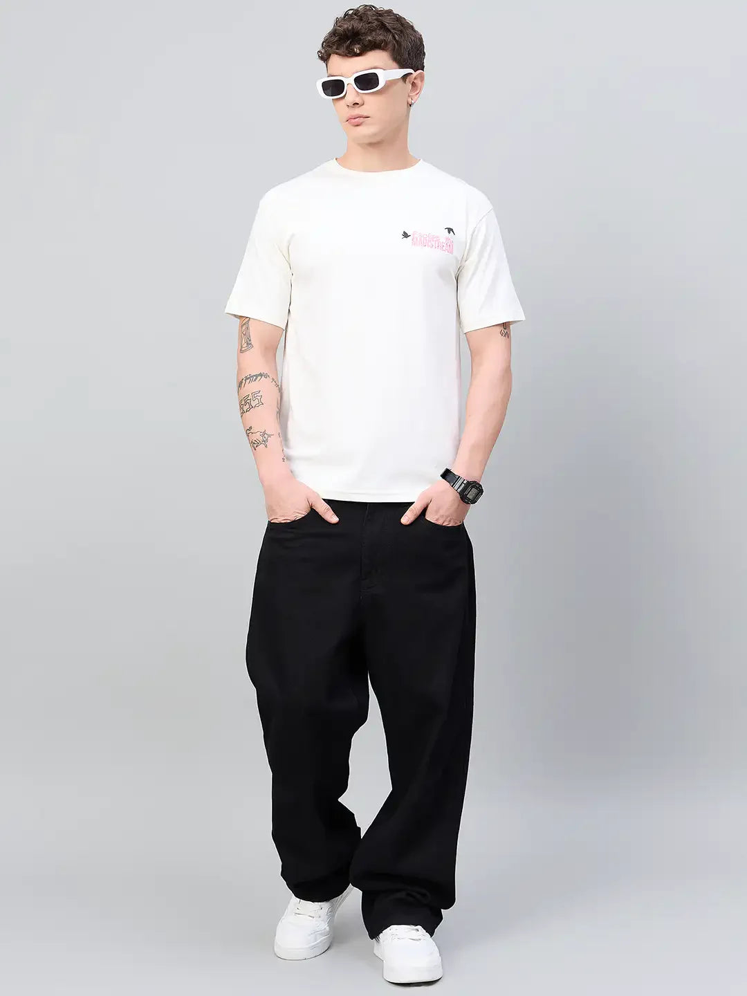 Man in 98degreenorth Typography Printed Offwhite Tee, black pants, white sneakers, and sunglasses for street style.