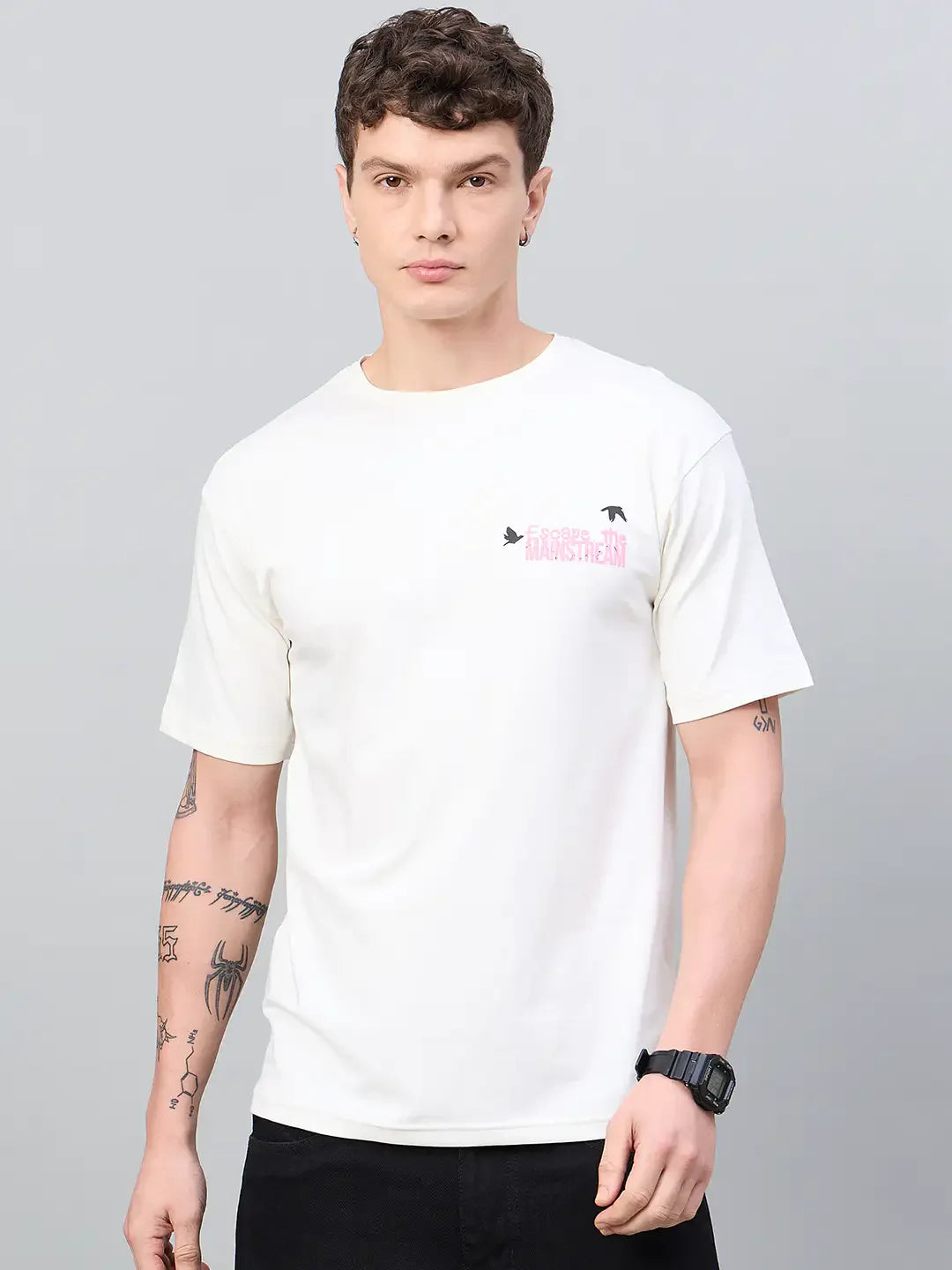 Man with short curly hair in a 98degreenorth Men Typography Printed Offwhite Round Neck T-shirt, black pants, and watch.