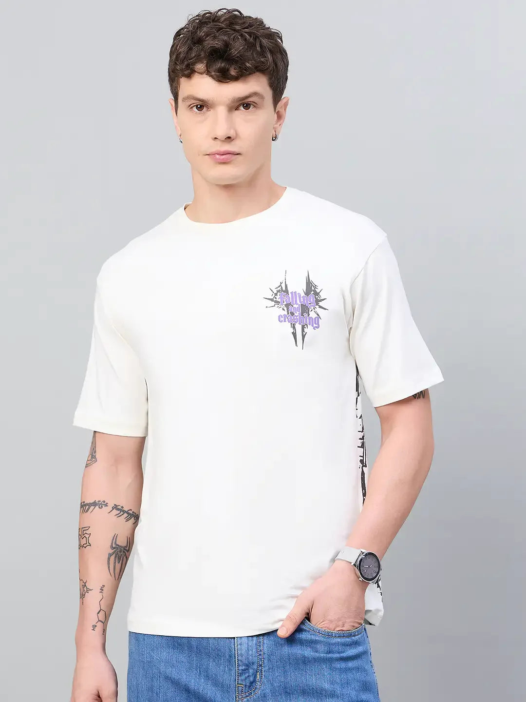 Man wearing a 98degreenorth Men Typography Printed Round Neck Offwhite T-shirt, blue jeans, and wristwatch.