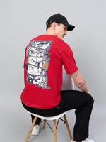 A man in a 98degreenorth Men Typography Printed Red T-shirt, black pants, and cap sits facing away on a chair.
