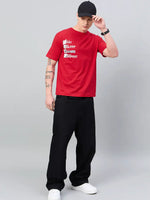 Man in an oversized 98degreenorth Men Typography Printed Round Neck Red T-shirt adjusts his black cap.