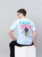 Person in blue sunglasses and an oversized 98degreenorth Men Typography Printed Round Neck Sky T-shirt faces away on block.