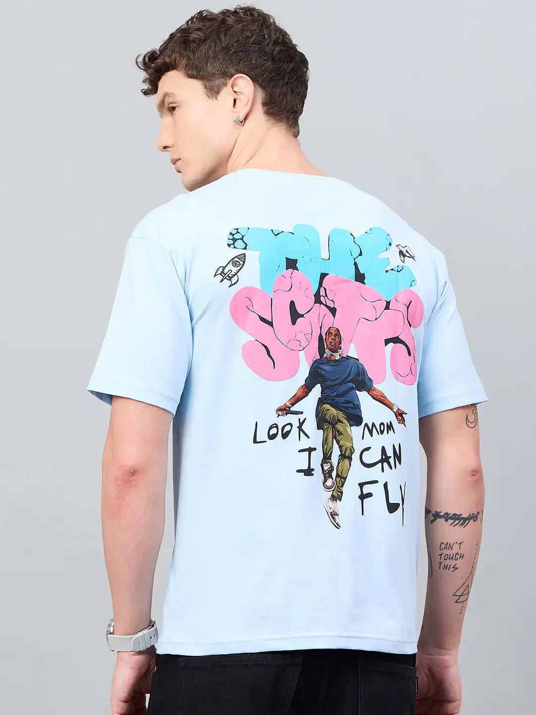 Man in an oversized 98degreenorth Men Typography Printed Round Neck Sky T-shirt with bold streetwear artwork on back.