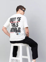 Man in sunglasses wears 98degreenorth Men Typography Printed Round Neck T-shirt - Offwhite, sitting on a stool.