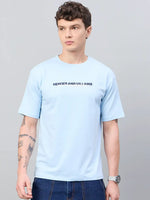 Man in a 98degreenorth Men Typography Printed Sky Round Neck T-shirt, blue jeans, and watch against a plain background.