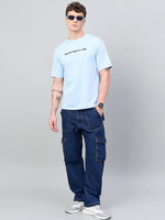 Man in 98degreenorth Men Typography Printed Sky Round Neck T-shirt poses against a plain gray background.