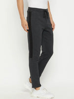 A man in 98degreenorth Anthra Fleece Trackpants with side stripe and a white shirt stands against a white background.