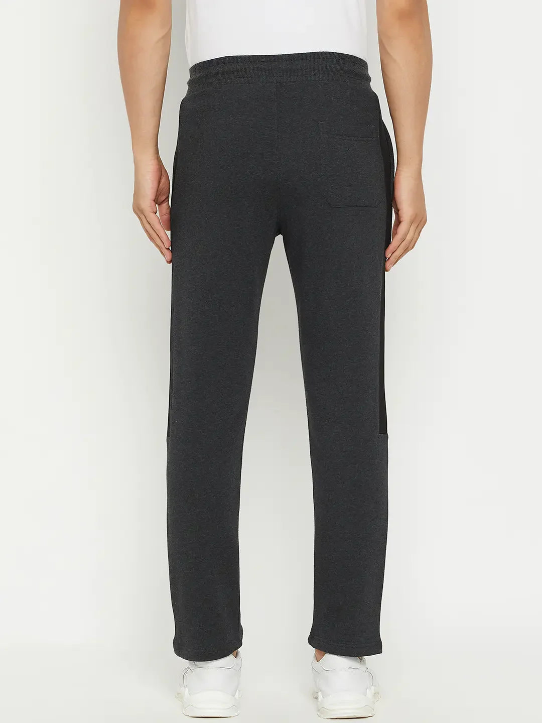Man in 98degreenorth Men’s Anthra Fleece Trackpants with Side Stripe, shown from the back on a white background.