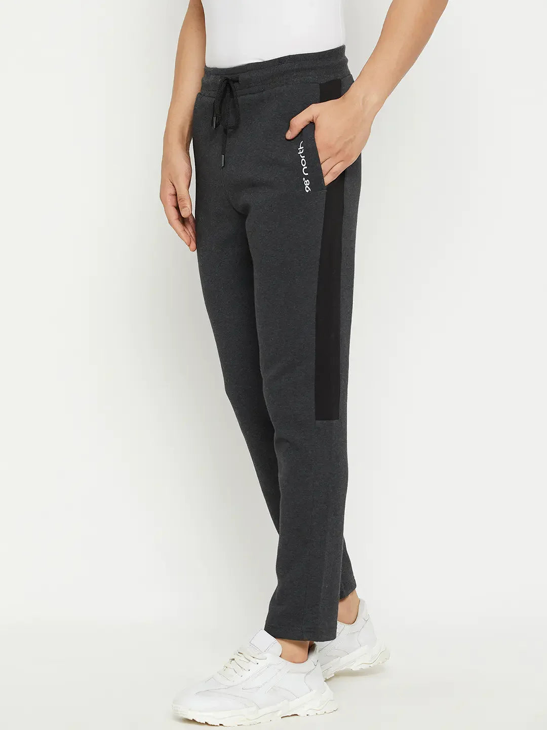 Man in 98degreenorth Men’s Anthra Fleece Trackpants with Side Stripe and white sneakers—ideal winter athleisure look.