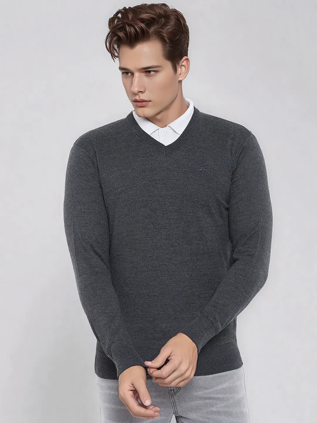 Young man in a 98degreenorth Men’s Anthra Merino Wool V-Neck Sweater, ideal for office or travel this winter.