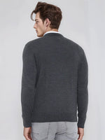 Man in a 98degreenorth Men’s Anthra Merino Wool V-Neck Sweater and light gray jeans, facing away.