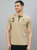 Man in 98degreenorth Men's Beige Aero Club No.3 Polo T-Shirt, smiling against a plain gray background.