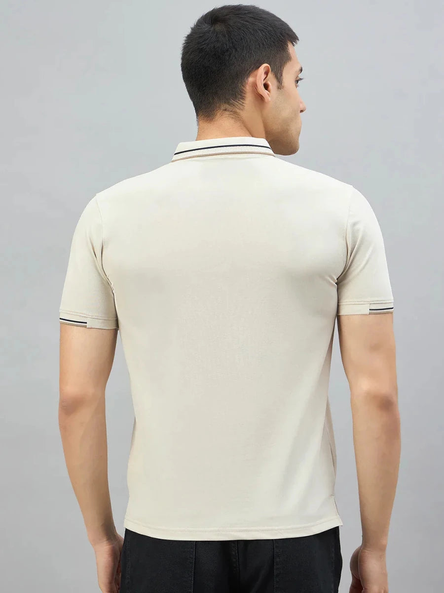 Man with short dark hair wears 98degreenorth Men's Beige Polo T-Shirt—Handmade Series, facing away against plain background.