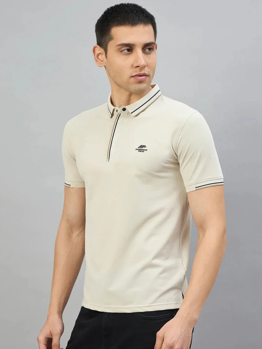 Man wearing 98degreenorth Men's Beige Polo T-Shirt — Handmade Series, with contrast tipping, against a gray background.