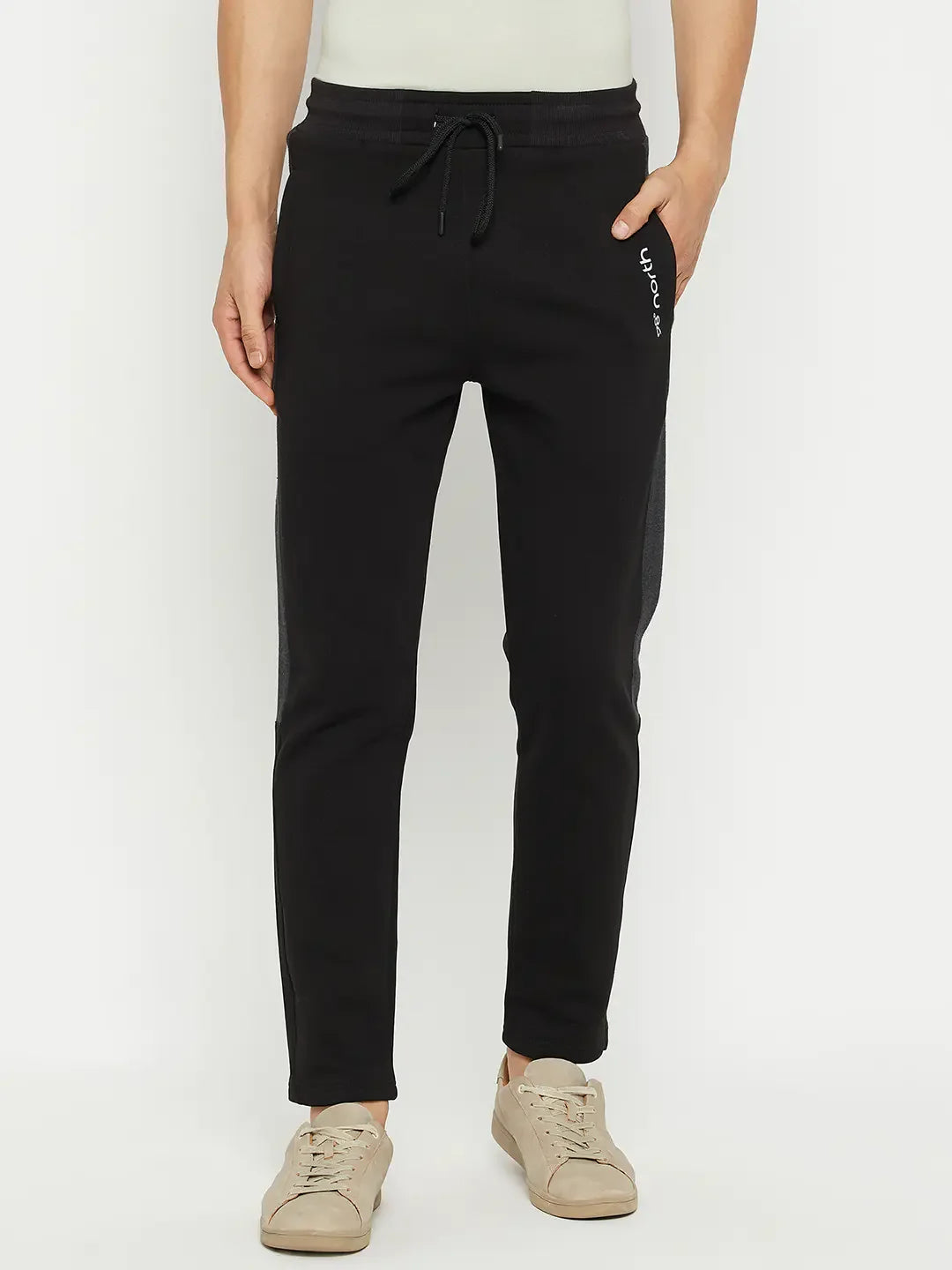 Man in 98degreenorth Men’s Black Fleece Trackpants with Side Design, paired with beige sneakers on a white background.