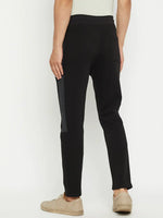 Man in 98degreenorth Men’s Black Fleece Trackpants with Side Design, facing away against a white background.