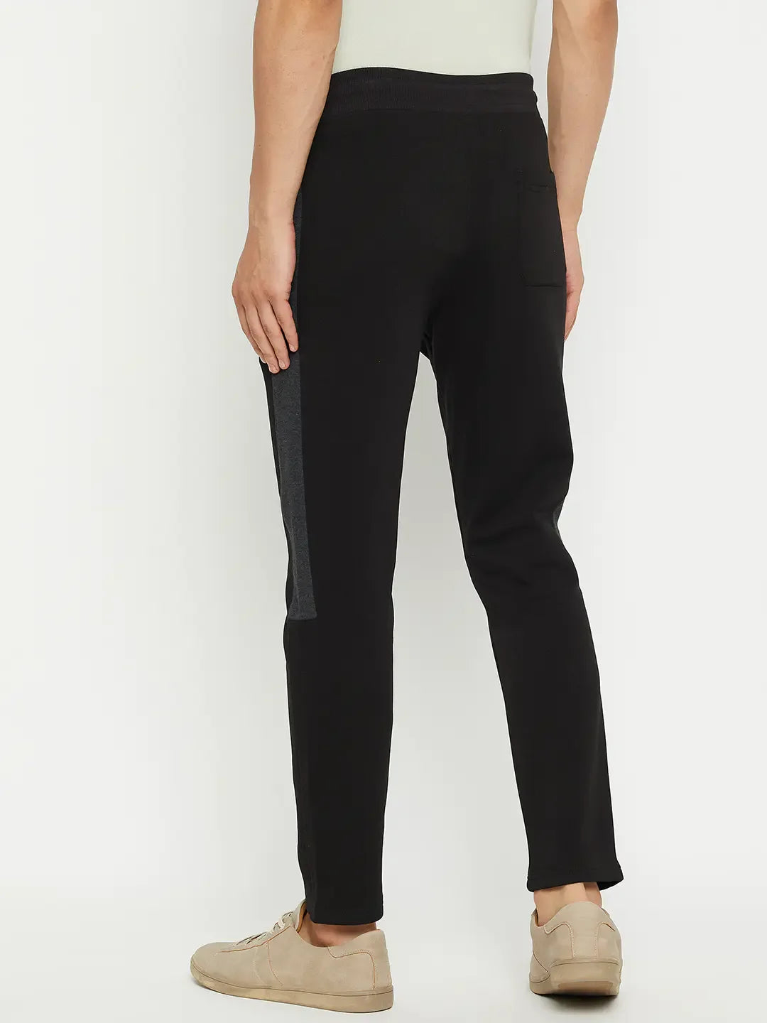 Man in 98degreenorth Men’s Black Fleece Trackpants with Side Design, facing away against a white background.