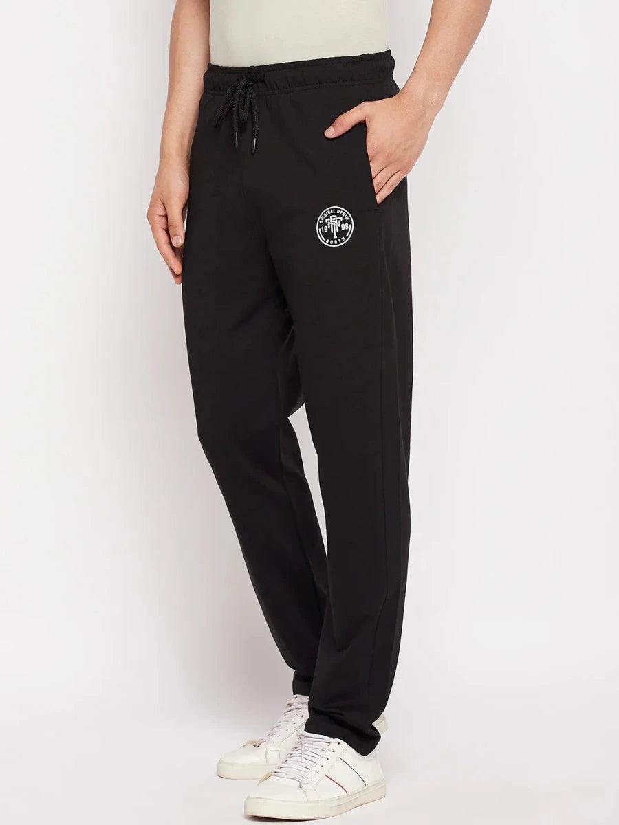 Man in 98degreenorth Men's Black French Terry Lycra Trackpants, white sneakers, and a light shirt.