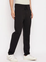 Man in 98degreenorth Men's Black French Terry Lycra Trackpants, standing against a plain white background.