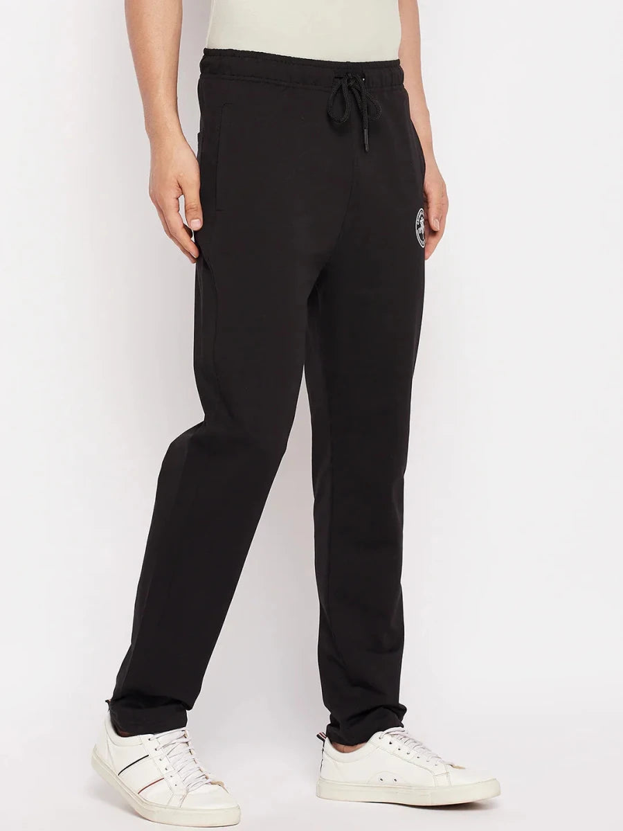 Man in 98degreenorth Men's Black French Terry Lycra Trackpants, standing against a plain white background.