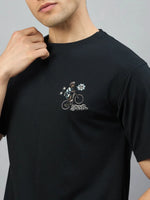 Man wears 98degreenorth Black Graphic Oversized T-Shirt with RockStar back print and streetwear chest detail.