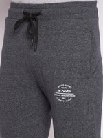 Close-up of 98degreenorth Men’s Black Jaspe Fleece Trackpants with drawstring waist and white text near left pocket.