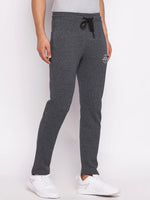 A man wears 98degreenorth Men’s Black Jaspe Fleece Trackpants—stretchable winter lounge pants and white sneakers.