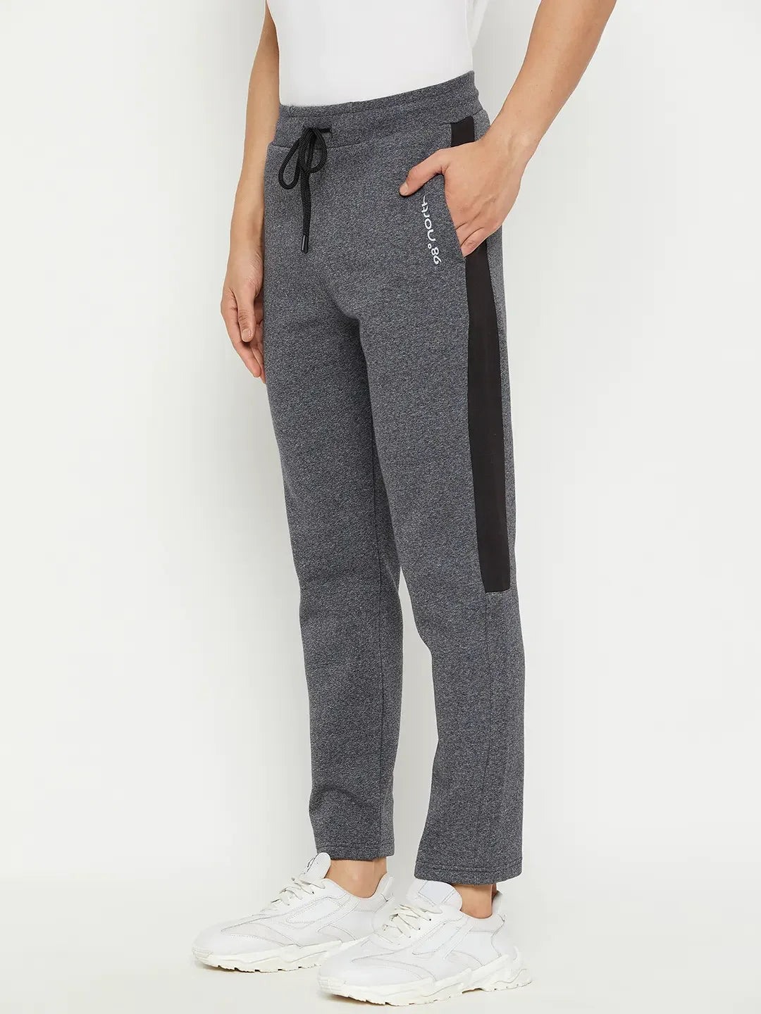 Person in 98degreenorth Men’s Black Jaspe Fleece Trackpants with side panel, white shirt, and white sneakers.