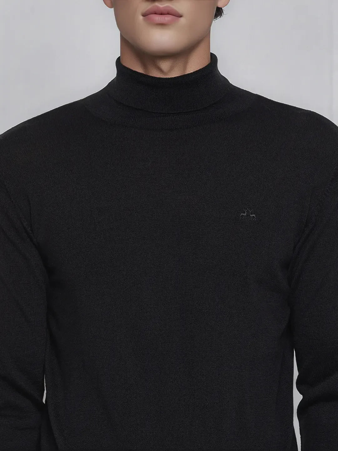 A man wears the 98degreenorth Men’s Black Merino Wool Turtle Neck Sweater, visible from shoulders to chin.