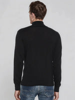 A man in a 98degreenorth Men’s Black Merino Wool Turtle Neck Sweater exudes classic, effortless winter elegance.