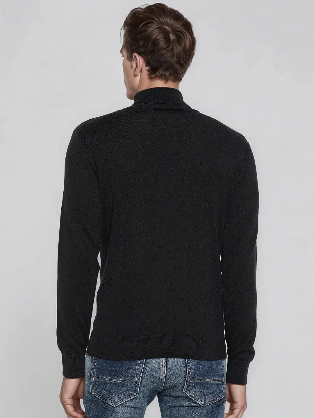 A man in a 98degreenorth Men’s Black Merino Wool Turtle Neck Sweater exudes classic, effortless winter elegance.