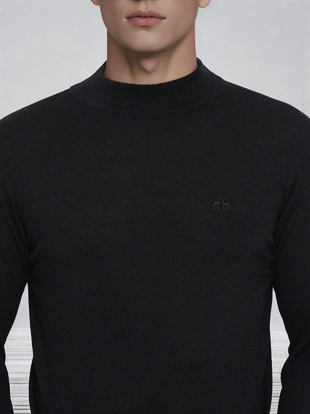 A man wearing a 98degreenorth Men’s Black Merino Wool Turtle Neck Sweater with a subtle chest logo.