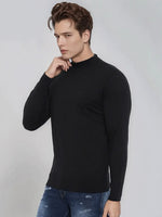 A man models the 98degreenorth Men’s Black Merino Wool Turtle Neck Sweater with blue jeans on a light gray background.