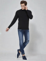 A man in glasses wears a 98degreenorth Men’s Black Merino Wool Turtle Neck Sweater against a light gray background.