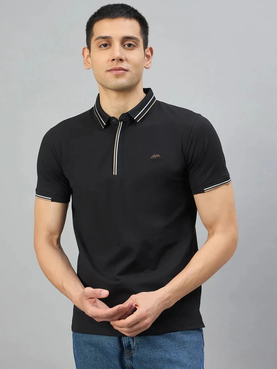 Man in 98degreenorth Men's Black Polo T-Shirt — Handmade Series, featuring contrast tipping, against grey background.