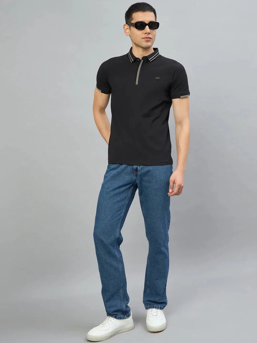 Man wears 98degreenorth Men's Black Polo T-Shirt — Handmade Series, standing against a plain gray background.