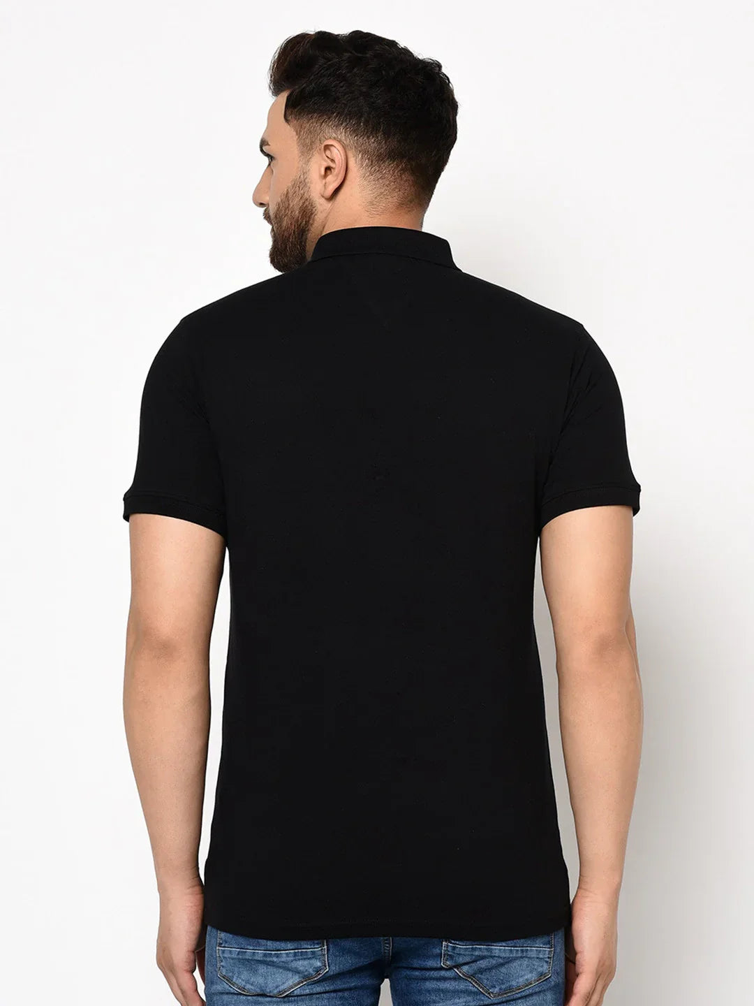 Man wearing 98degreenorth Men's Black Polo T-Shirt—Stretch Cotton Pique Knit, facing away against a plain background.
